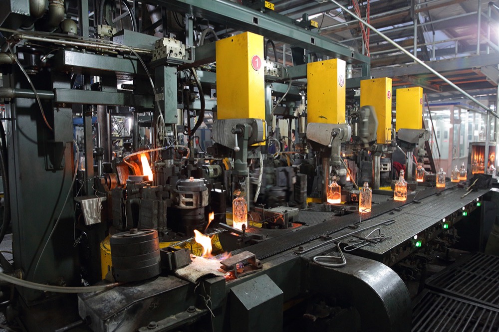 IS forming machines shaping hot super-flint spirits bottles at the Shandong factory