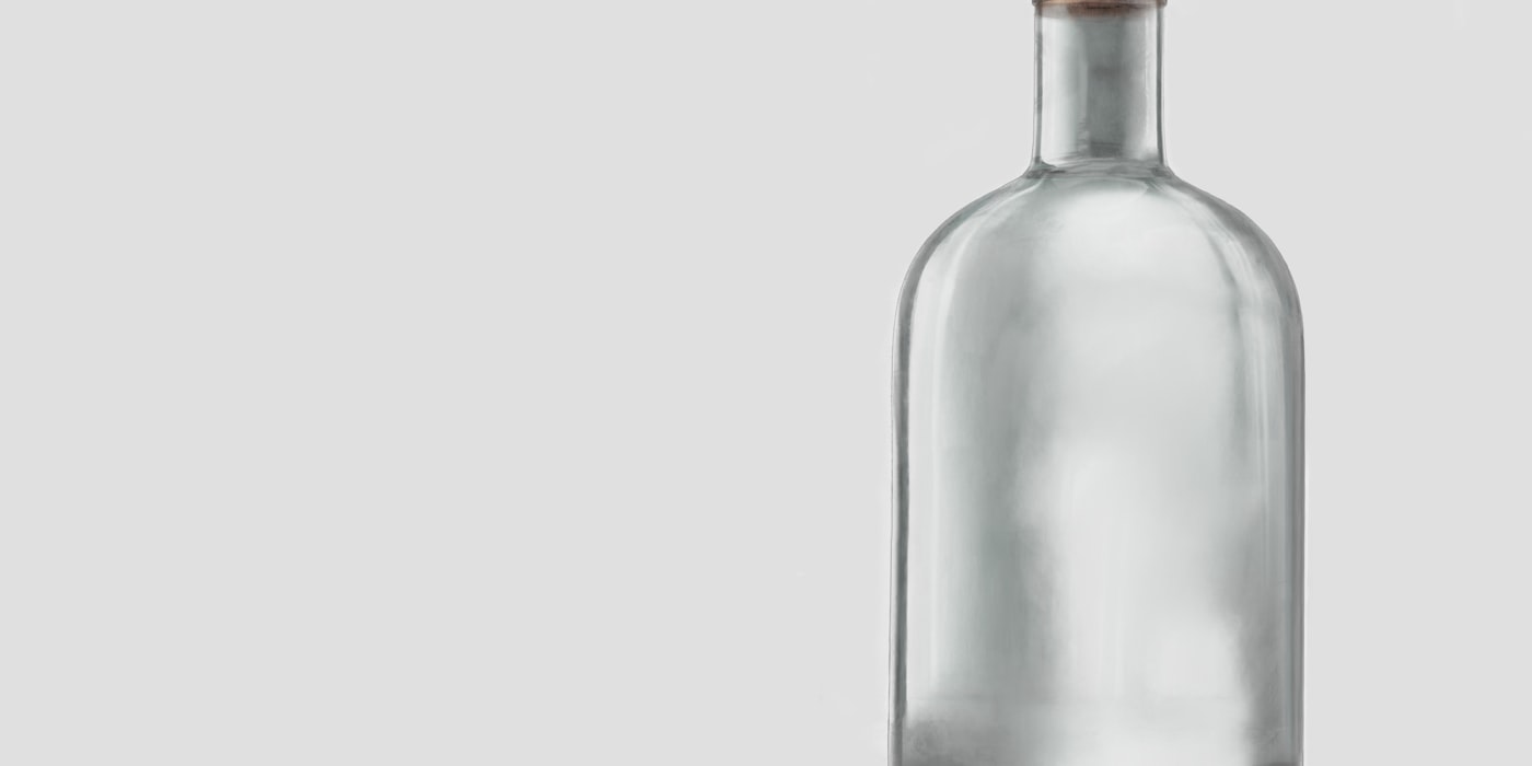 A clear glass bottle with a cork stopper photographed on a plain grey background