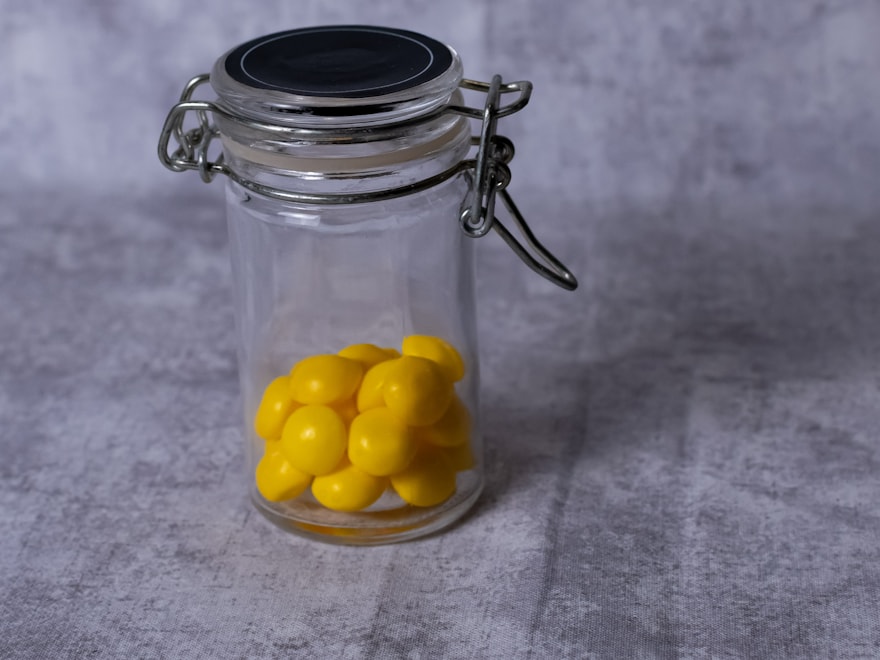 Clear glass candy jar with a clamp lid on a slate surface