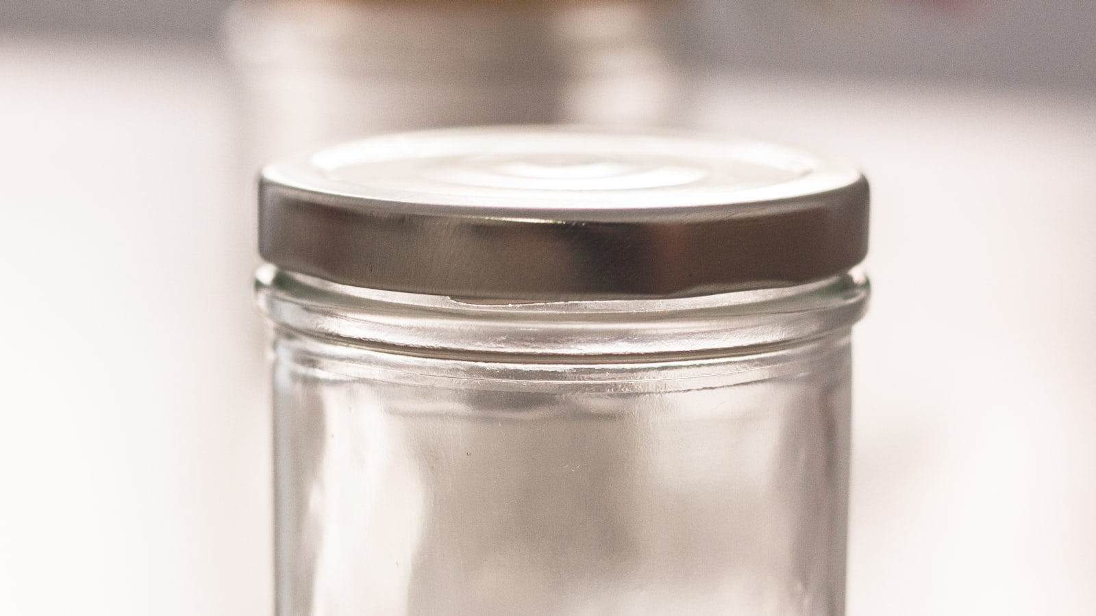 A clear glass jar closed with a silver metal twist-off lid