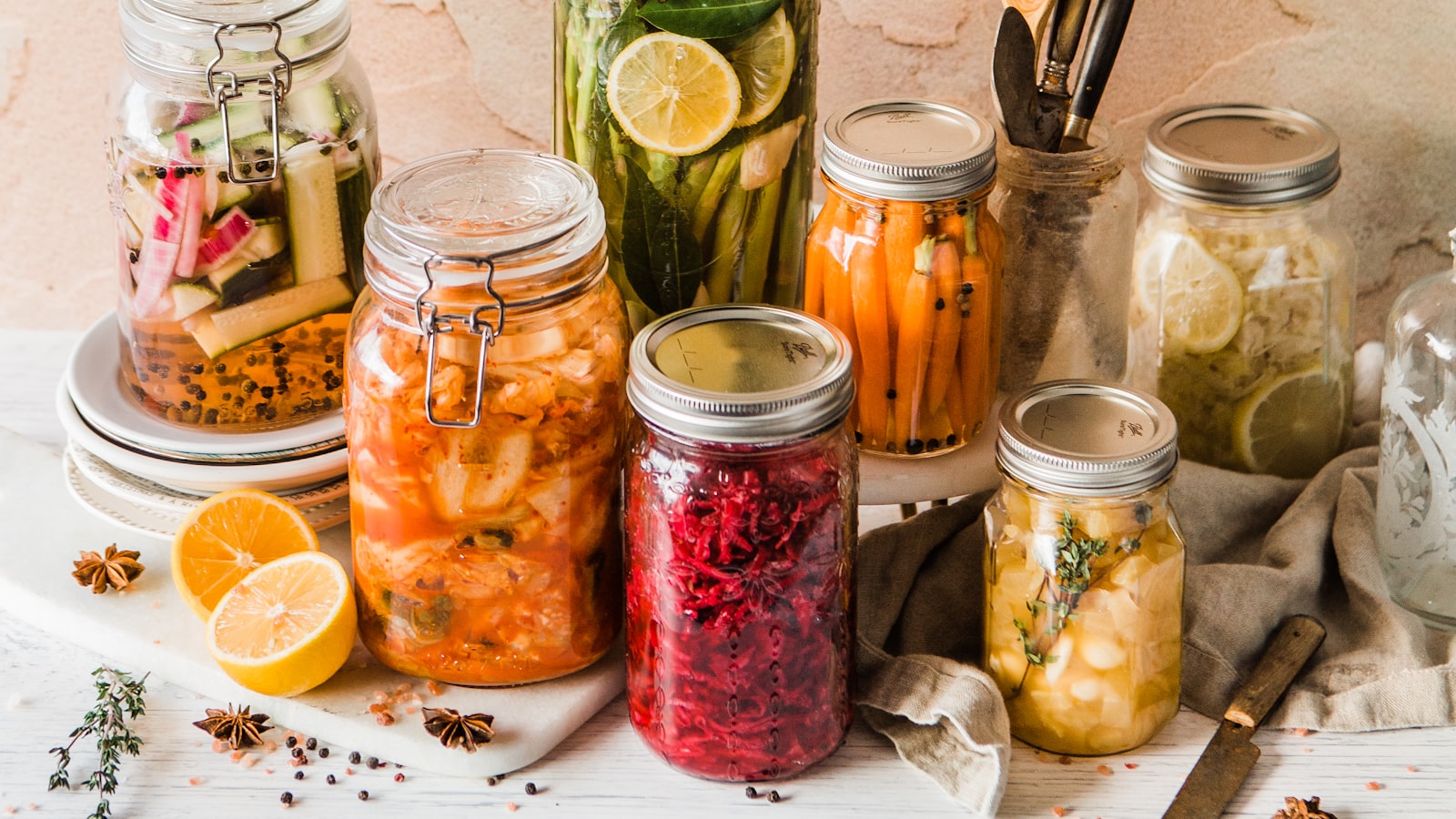 Preserve jars with metal lids styled on a table with lemons and spices