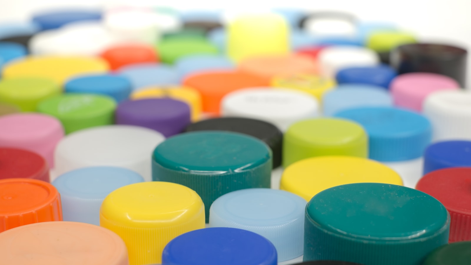 Coloured plastic screw caps arranged in rows