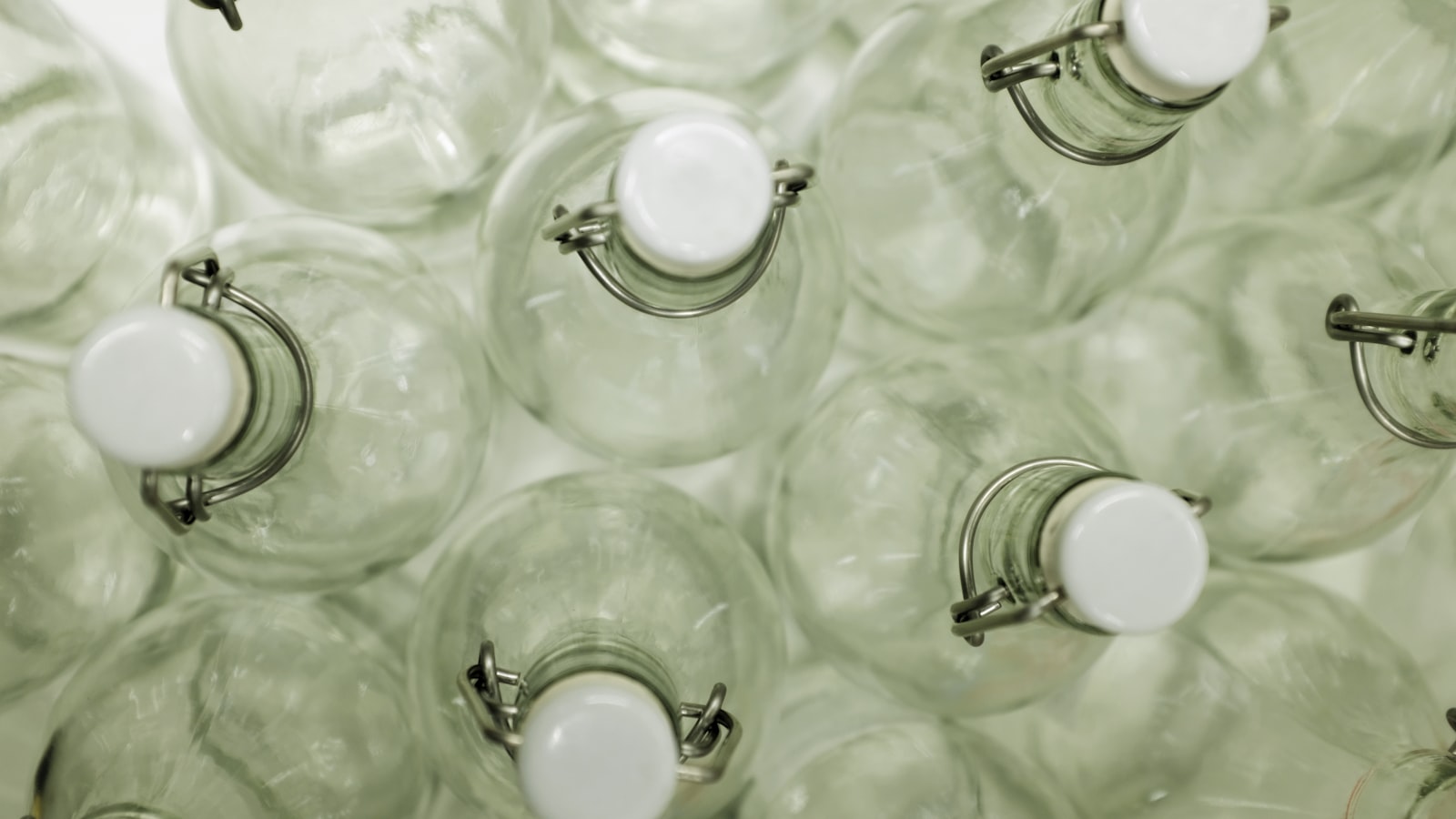 Swing-top glass bottles seen from above, showing their ceramic stoppers and wire bails