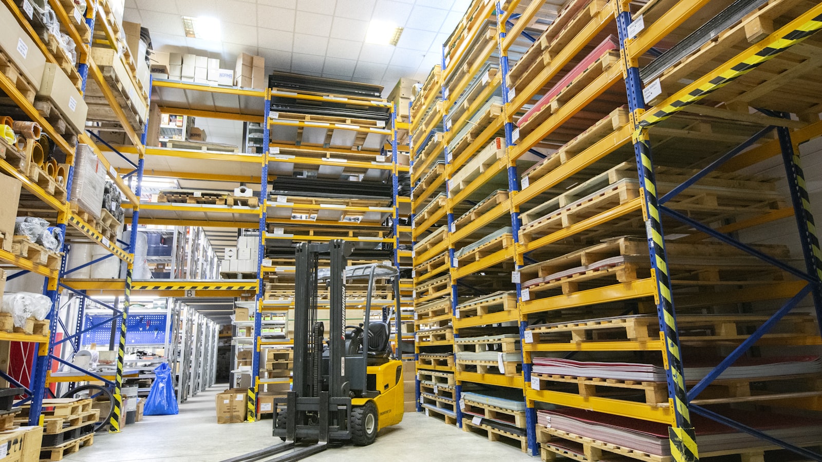 Pallets of glass moving through a warehouse aisle