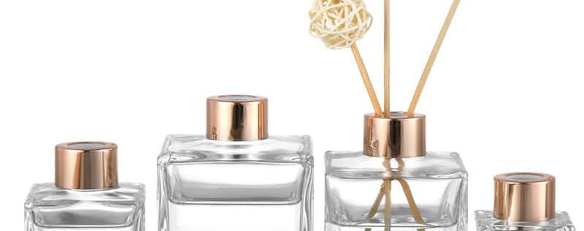 Glass diffuser bottles standing together on a pale surface