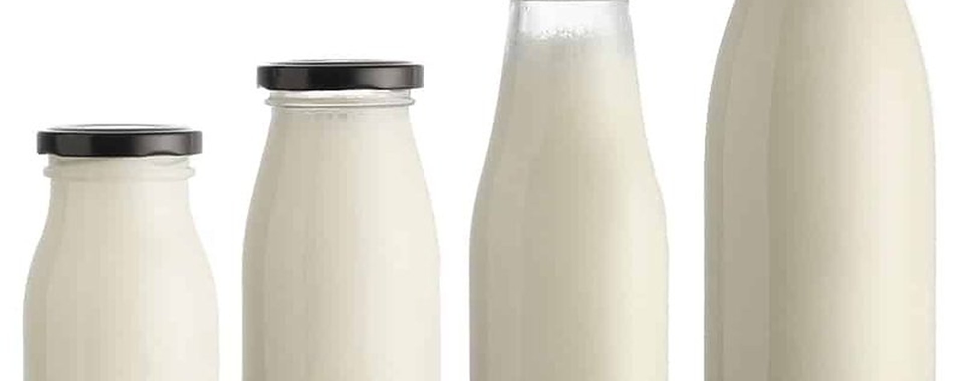 Botellas redondas clásicas de vidrio para leche en cuatro tamaños, llenas de leche, con tapa oscura a rosca