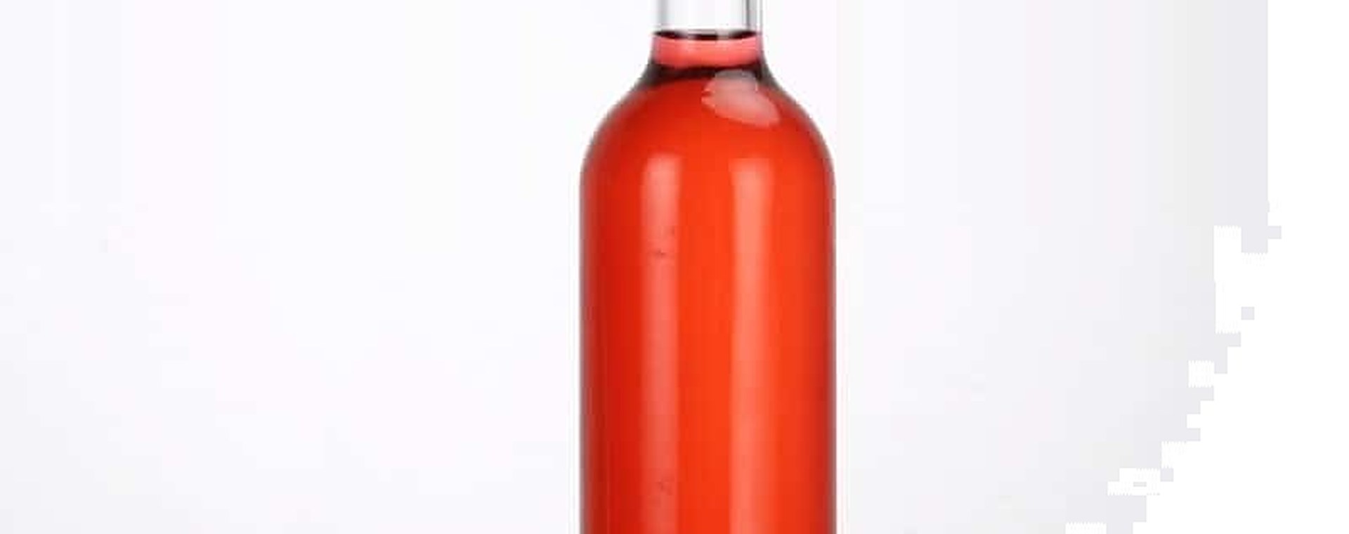 Hohe schlanke Eisweinflasche mit roséfarbenem Wein und goldener Kapsel