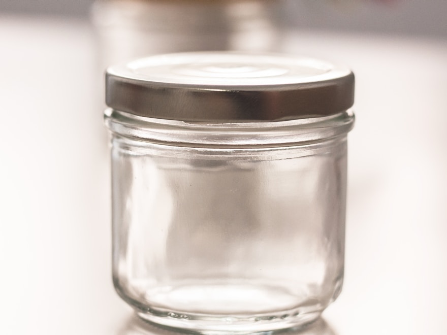 Clear glass candle jar with a metal lid