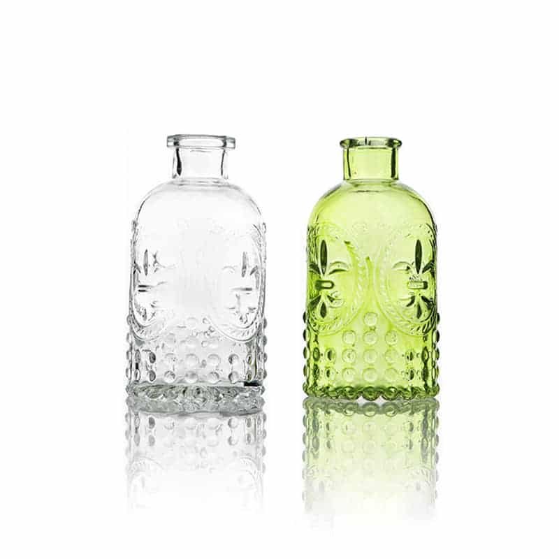 Zwei geprägte Diffuserflaschen aus Glas, eine klar und eine grün