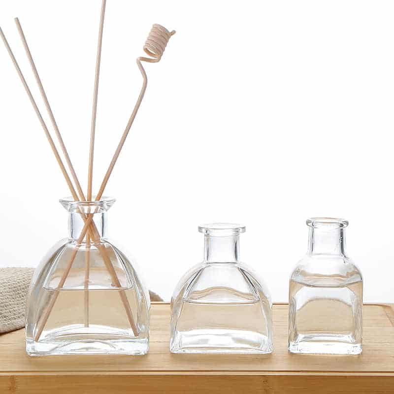 Drei gewölbte Diffuserflaschen aus Glas als Größenstaffel, mit Stäbchen