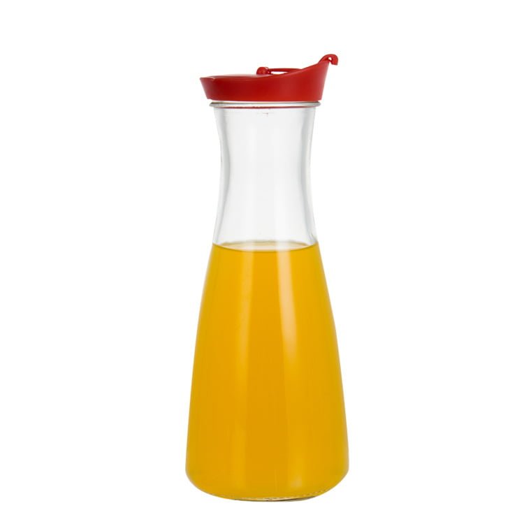 Botella de vidrio tipo garrafa de un litro con tapa vertedora roja, llena de jugo
