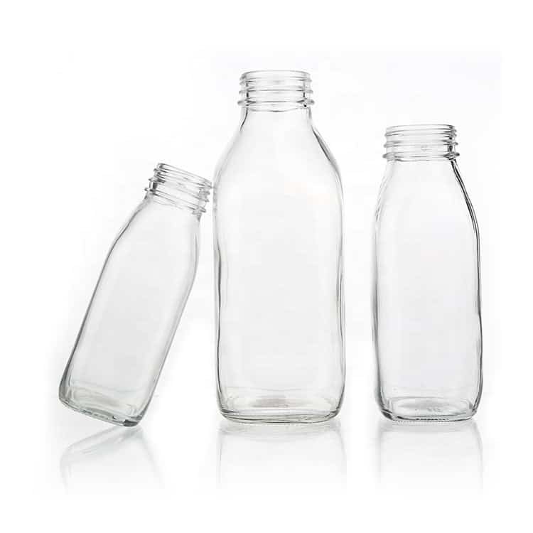 Botellas French Square de vidrio para leche con tapa negra a prueba de manipulación, sobre fondo liso
