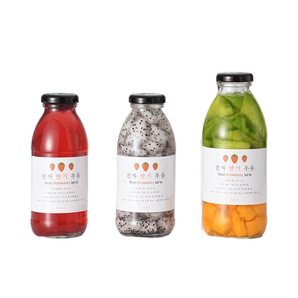 Tres botellas lácteas de vidrio de pared recta con etiqueta de papel, llenas de bebidas de fruta