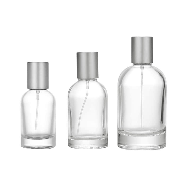 Tres frascos de perfume redondos con collarines de atomizador plateados