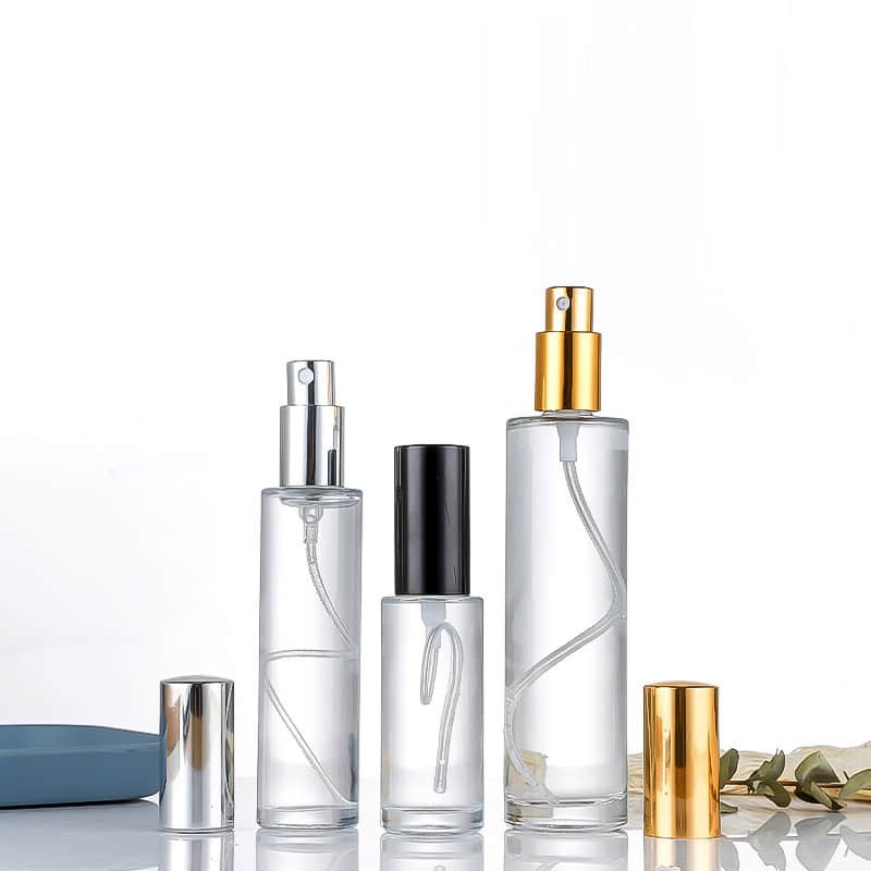 Frascos de perfume cilíndricos esbeltos con bombas atomizadoras en plateado y dorado
