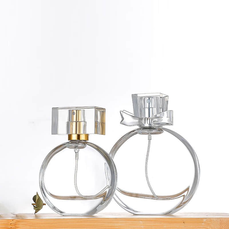 Dos frascos de perfume redondos planos con tapas moldeadas transparentes
