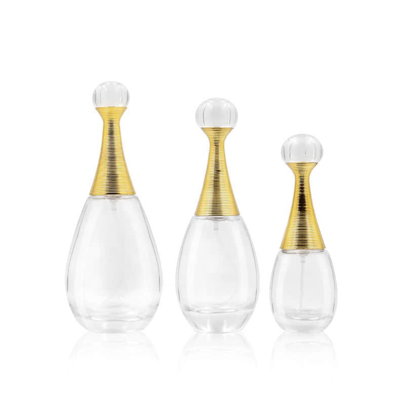 Tres frascos de perfume en forma de gota con collarines dorados y tapones esféricos