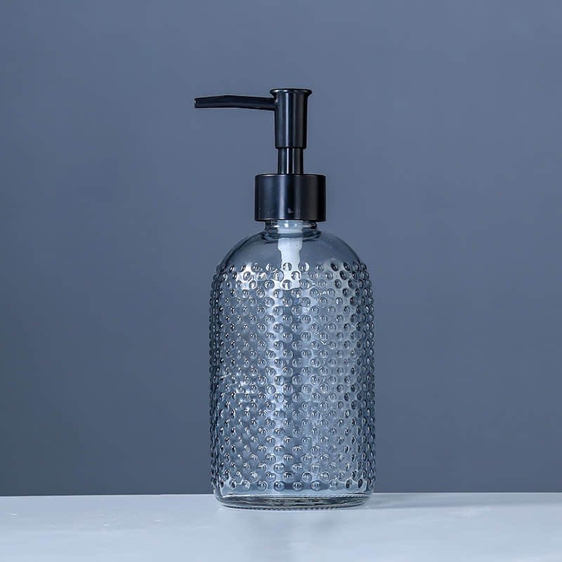 Facettierter Seifenspender aus hellblauem Glas mit schwarzer Pumpe