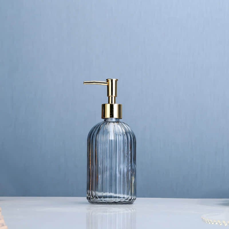 Geriffelter Seifenspender aus hellblauem Glas mit goldener Pumpe