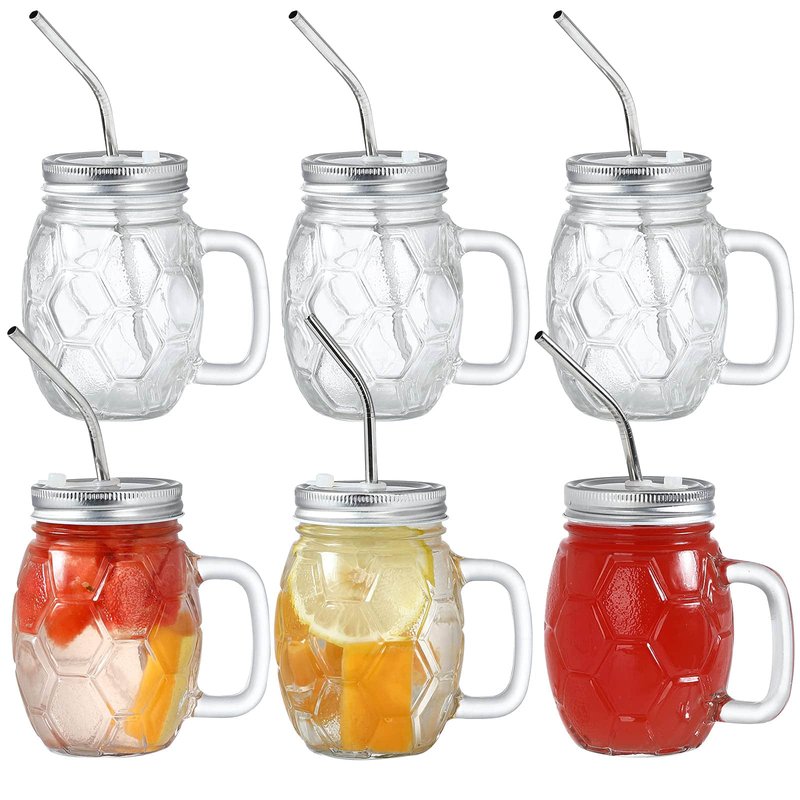 Sechs facettierte Mason-Becher aus Glas mit Henkel und Metall-Trinkhalmen, teils mit Fruchtgetränken gefüllt