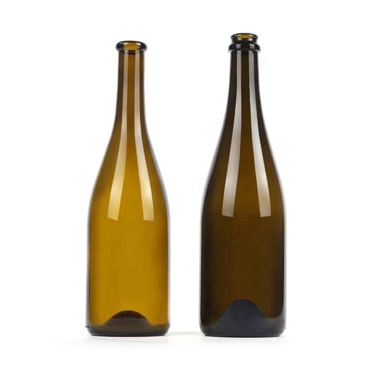 Two heavy sparkling wine bottles in amber and dark green, empty