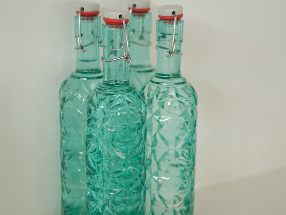 Teal glass swing-top bottles with an embossed diamond pattern